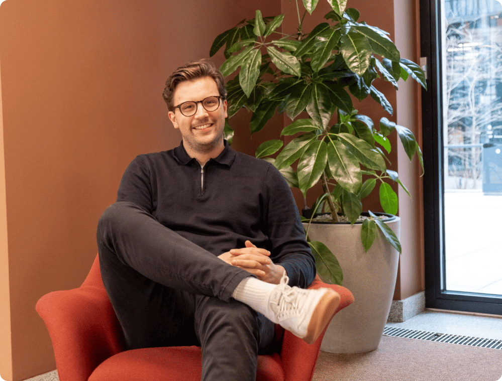 a brown, male bluetree employee in a red chair