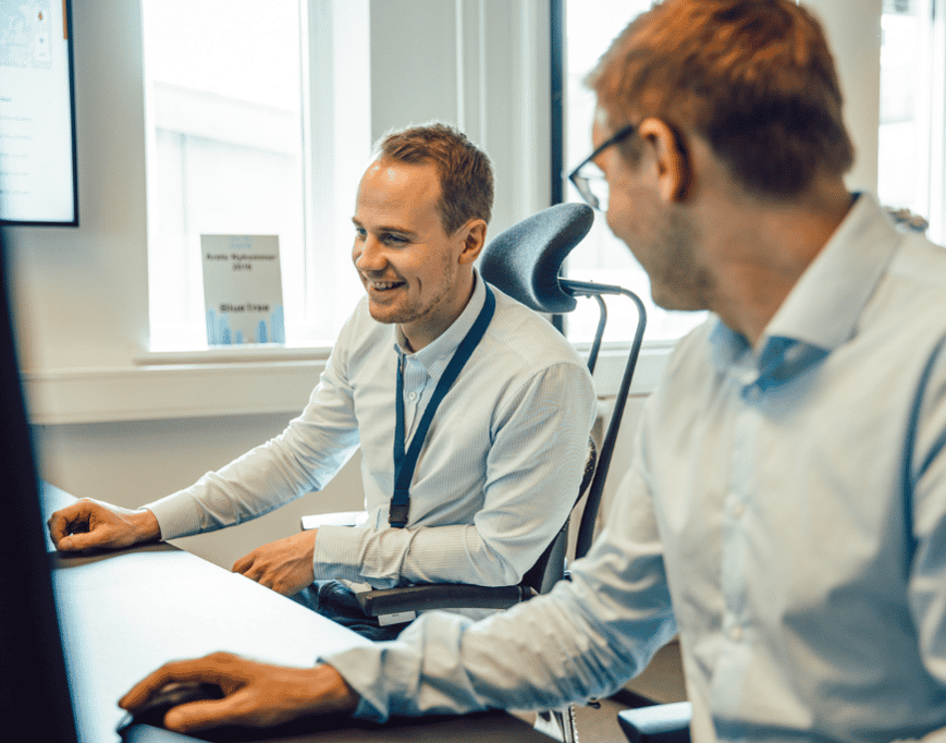 to smiling IT advisors talking in front of their computer